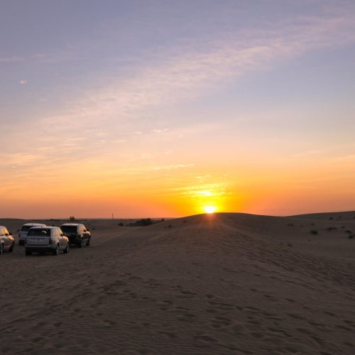 a group of cars parked on a sandy hill