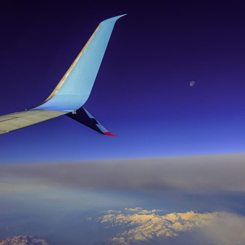 the wing of an airplane flying over the clouds